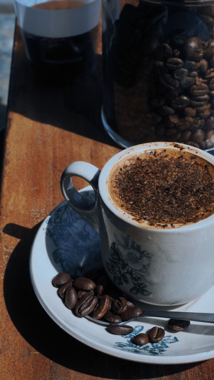 Mastering the First Impression: Your intriguing post title goes here Ceramic cup of coffee with beans on a saucer, in sunlight, creating a cozy aesthetic.
