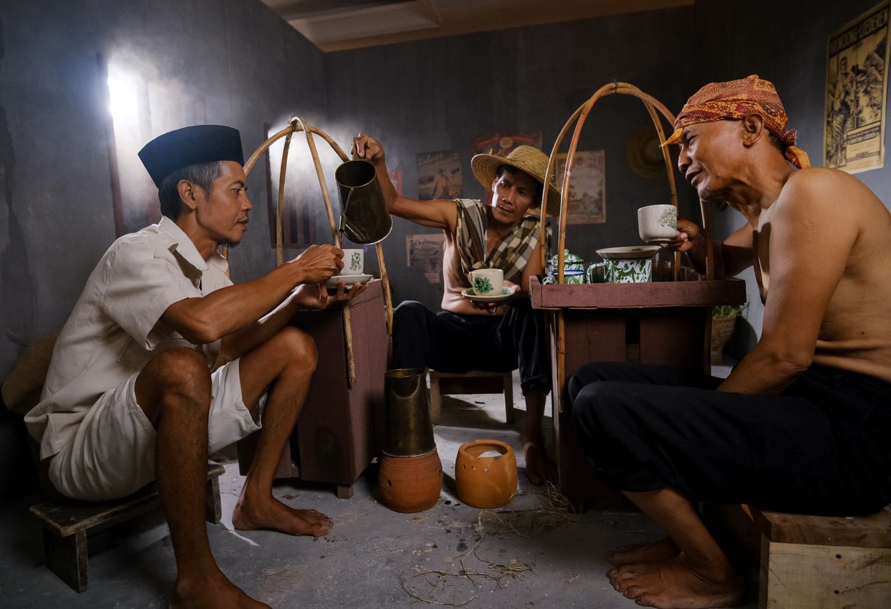 Crafting Captivating Headlines: Your awesome post title goes here Men enjoying a social coffee break in a traditional Indonesian setting.